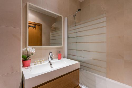 La salle de bains est pourvue d'un lavabo et d'un miroir. dans l'établissement GuestReady - City Blossom, à Porto