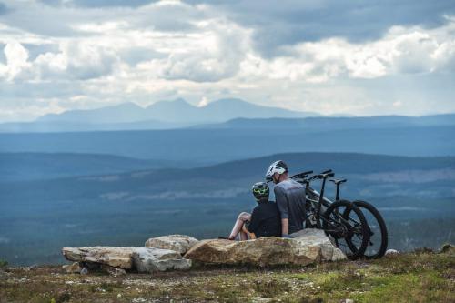 two people sitting on a rock with their bikes at The Riverside Mountain Lodge - 110sqm clam luxury - including bed linens, towels, in Idre