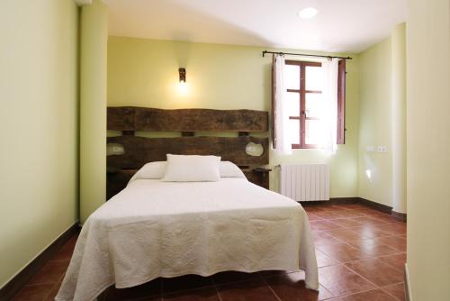 a bedroom with a white bed and a window at Hotel Rural Frías in Trias