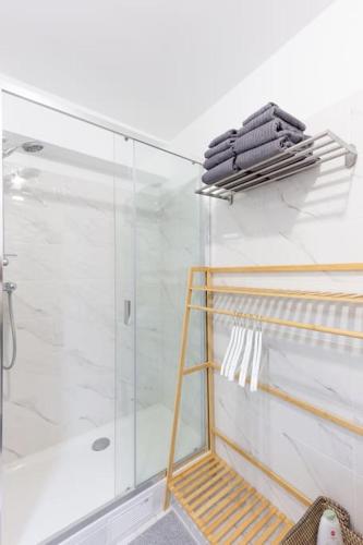 La salle de bains est pourvue d'une douche et d'une cabine de douche en verre. dans l'établissement Cocoon de Luxe - Oasis Paris Lisbonne, au Plessis-Robinson
