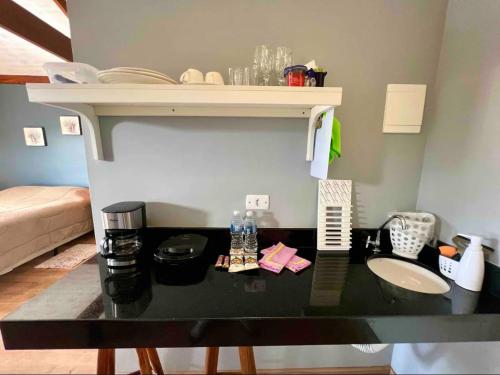 a black counter top in a room with a sink at Suite Lavanda in Santo Antônio do Pinhal