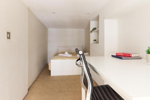 een slaapkamer met een bed in een witte kamer bij Charming 1-Bed Apartment in London in Londen