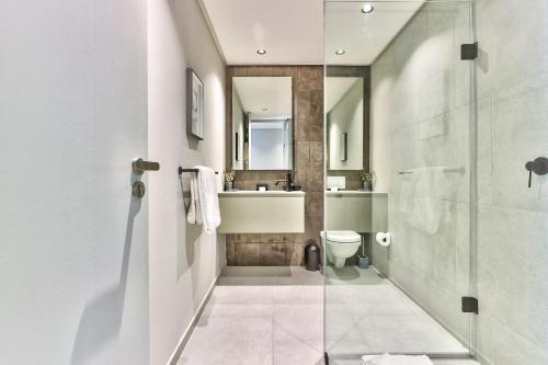 Cape Town的住宿－The Quarter Apartments，带淋浴、卫生间和盥洗盆的浴室
