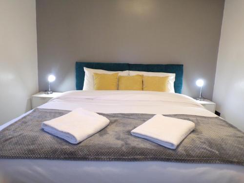 a large bed with two white towels on it at Hazelhurst House - 4 bedrooms 2 bathrooms in Stoke on Trent
