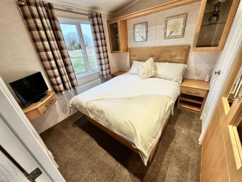 1 dormitorio pequeño con 1 cama y TV en Impeccable 2-Bed Lodge in Preston hot hub, en Preston