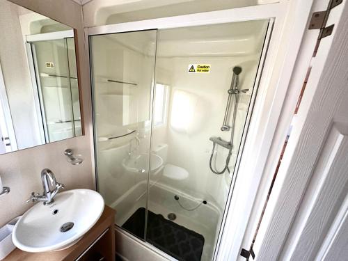 y baño con ducha y lavamanos. en Impeccable 2-Bed Lodge in Preston hot hub, en Preston
