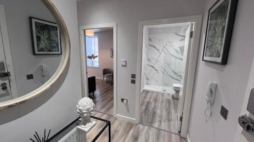 a hallway with a round mirror and a bathroom at St John's Apartments in Perth