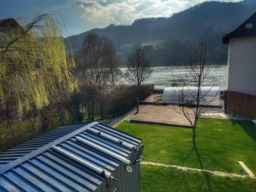 vista su un cortile con una casa e un lago di Bungalow Donaublick mit Pool und Garten a Sankt Nikola an der Donau