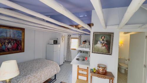 a small bedroom with a bed and a kitchen at APCH V7 Torreón in Chinchón