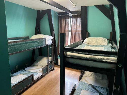 بيت شباب أمستردام أبتاون في أمستردام: سريرين بطابقين في غرفة مع جدران زرقاء