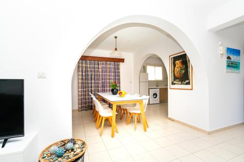 eine Küche und ein Esszimmer mit einem Tisch und Stühlen in der Unterkunft Kotsias Corallia Villas in Coral Bay