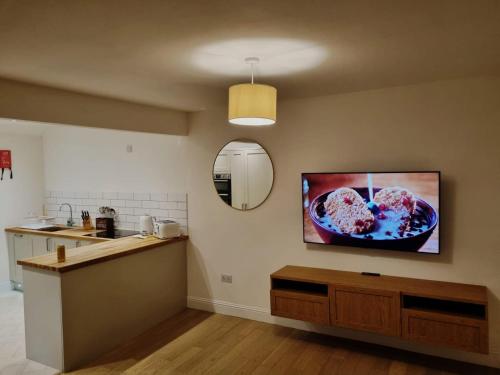 a kitchen with a tv on the wall at Oban Lorne Apartment in Oban