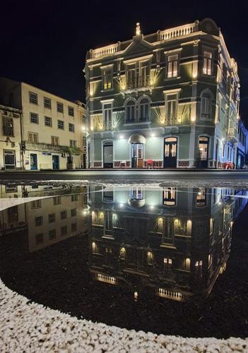 a building with its reflection in a pool of water at Internacional Azores Boutique in Horta