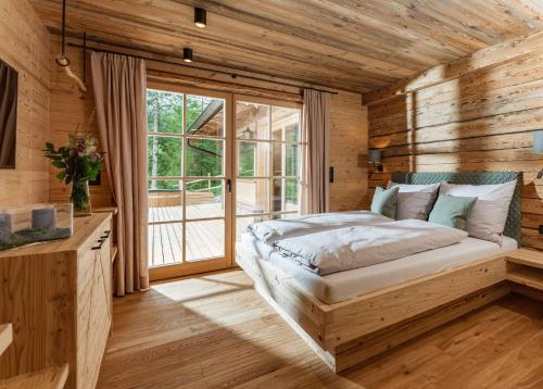 ein Schlafzimmer mit einem Bett und einem großen Fenster in der Unterkunft Almchalet zu Pruggern bey FeWo-PLAN in Pruggern