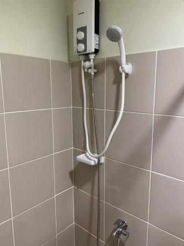 a shower with a microphone in a bathroom at Brenthill Condo (Ceramic Unit) in Baguio
