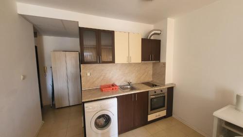 a kitchen with a sink and a washing machine at Студио Костови Имоти in Sveti Vlas