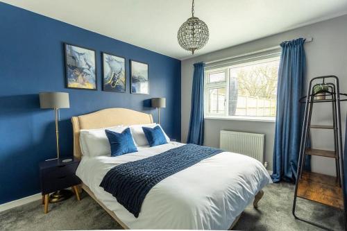 a blue bedroom with a bed with blue walls at WOODFIELD ROAD - Two bed in Harrogate with cosy living room fire. in Harrogate