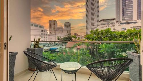 a balcony with chairs and a view of a city at Miami Hotel Cartagena - Luxury Apartments in Cartagena de Indias