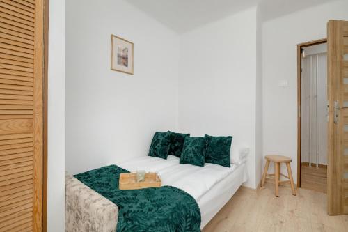 - un lit blanc avec des oreillers verts dans l'établissement Comfortable Apartment with Balcony in Krakow by Rent like home, à Cracovie
