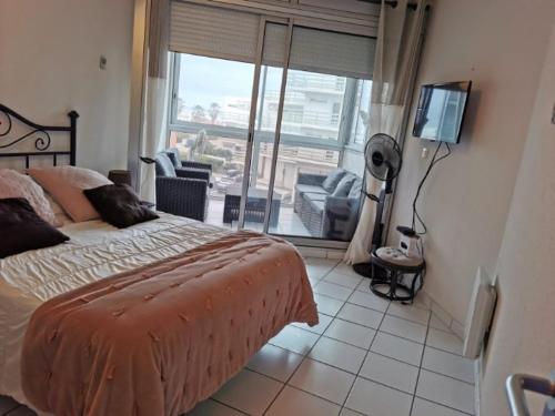1 dormitorio con cama y ventana grande en Appartement vu sur la mer, en Port Leucate