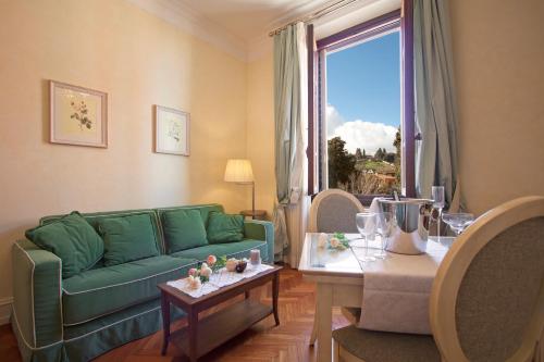 a living room with a green couch and a table at Serristori Palace Residence in Florence