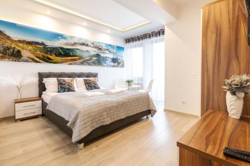 a bedroom with a bed and a painting on the wall at Apartamenty & Spa Stara Polana in Zakopane