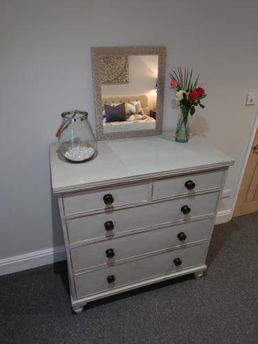 a dresser with a mirror on top of it at Newly renovated 2-bed bungalow in Bath