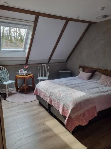 a bedroom with a bed and a table with chairs at Bed & Breakfast aan de Beek in Arcen