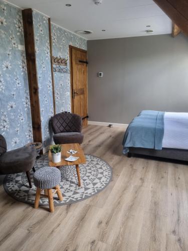 a bedroom with a bed and a table and chairs at Bed & Breakfast aan de Beek in Arcen