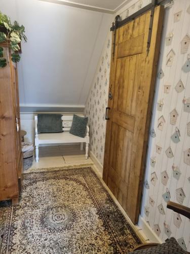 a room with a wooden door and a bench at Bed & Breakfast aan de Beek in Arcen