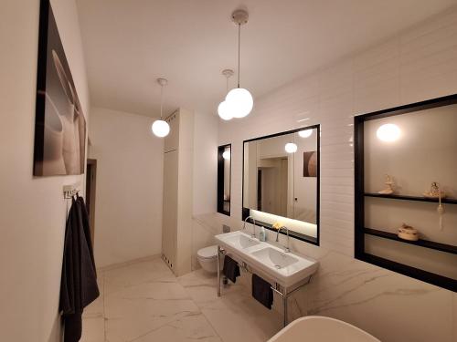 a bathroom with a sink and a toilet and a mirror at Apartmán Sarlot (13) in Bratislava