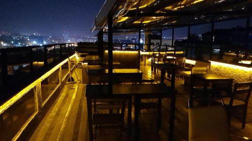ein Restaurant mit Tischen und Stühlen auf einem Balkon in der Nacht in der Unterkunft KADIKÖY BRISTOL HOTEL in Istanbul