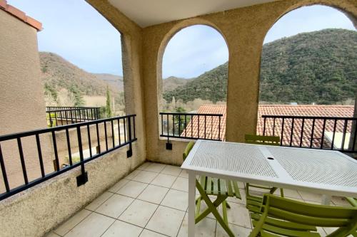 a balcony with a table and chairs and mountains at Les Naïades I53 - 2 bedrooms for 5 people ! in Avène