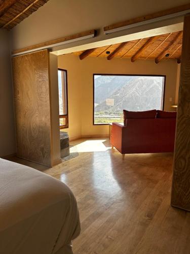 1 dormitorio con cama, sofá y ventana en Cabañas Bodega Kindgard en Purmamarca