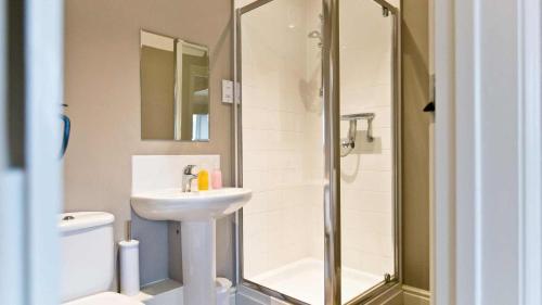 een badkamer met een douche, een wastafel en een toilet bij Manifold Farmhouse in Belper