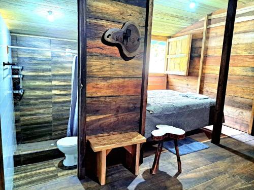 a bathroom with a shower and a toilet and a bed at Rainforest Hut in Archidona