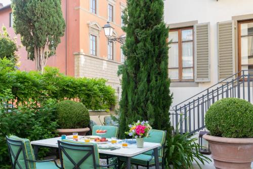 a patio with a table and chairs and trees at Serristori Palace Residence in Florence