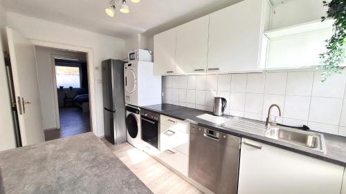 een keuken met witte kasten en roestvrijstalen apparatuur bij Helles Apartment für 5 Personen in Schwerte