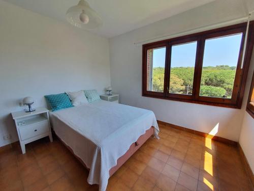 a bedroom with a bed and a large window at COSTA BRAVA SUITES Casa El Turó de Sagaró in S'Agaro