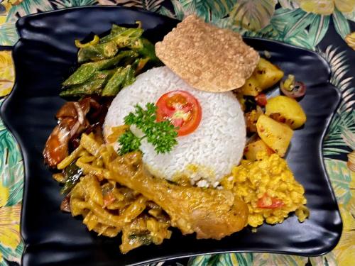 um prato de alimentos com arroz e diferentes alimentos em MILLET'S FOOD COMPANY AND COOKING CENTER em Negombo