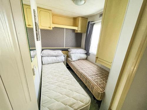 mały pokój z 2 łóżkami i oknem w obiekcie 8 Berth Caravan With Wifi At Dovercourt Holiday Park In Essex Ref 44009e w mieście Great Oakley