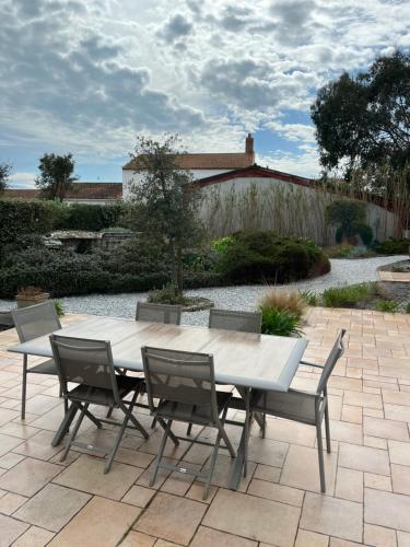 a white table and chairs on a patio at Les Chênes Verts in Le Grand Vieil