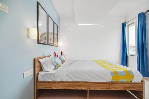 een slaapkamer met een bed met blauwe gordijnen bij OYO Home Hotel Fort Inn Near Golconda Fort in Haidar Sāhibgūda