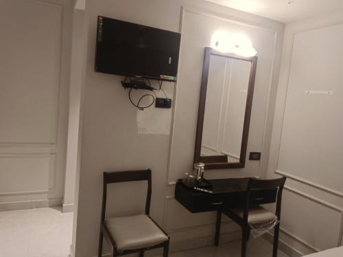 1 dormitorio con escritorio, espejo y silla en ARUNACHALA INN, en Kanyakumari