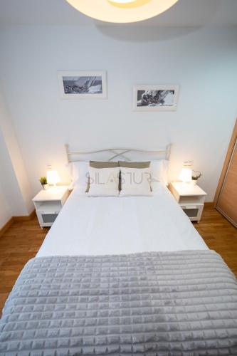 a bedroom with a large bed with two night stands at Dúplex Nalón in San Juan de la Arena