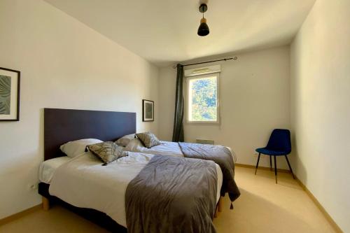 a bedroom with two beds and a blue chair at Les Naïades C08 - 2 bedrooms for 5 people ! in Avène