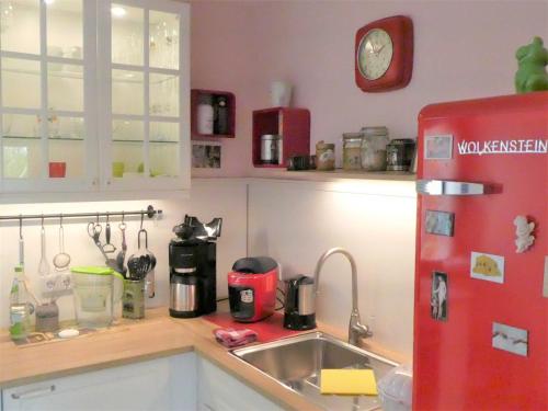 a kitchen with a red refrigerator and a sink at Ferienwohnung Kurparkblick in Bad Windsheim