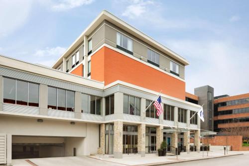 Hampton Inn and Suites Clayton/St. Louis-Galleria Area في كلايتون: مبنى أمامه علم أمريكي