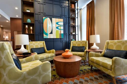 Hampton Inn and Suites Clayton/St. Louis-Galleria Area في كلايتون: غرفة معيشة مع كراسي صفراء وطاولة