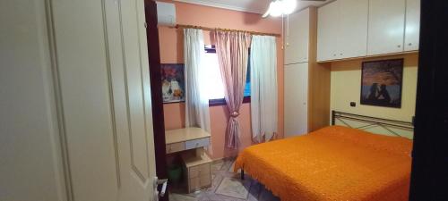 1 dormitorio con cama de color naranja y ventana en Nightflower rooms en Sami